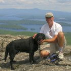 Paul Casazza and Cozmo enjoying Lake Winnipesaukee views while hiking the Lakes Region.